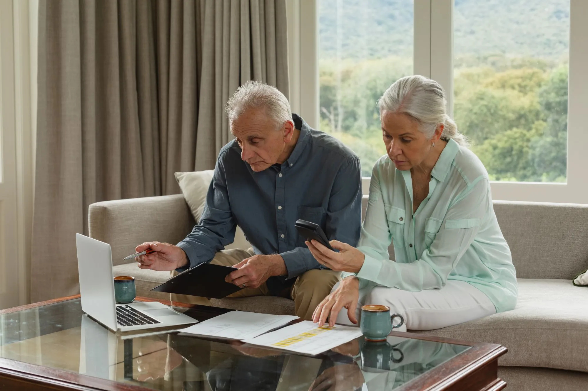active-senior-couple-calculating-bills-living-room