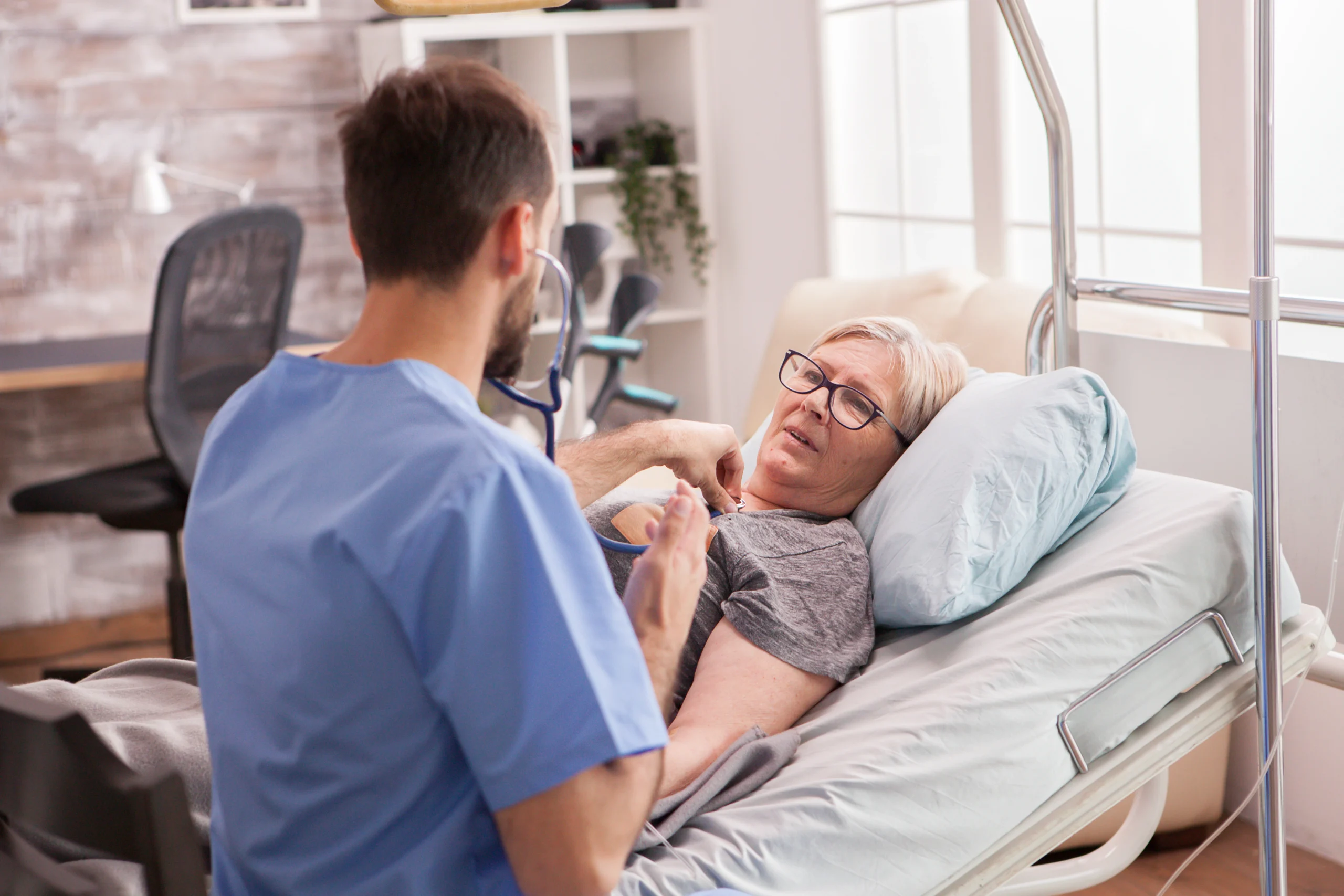 back-view-male-doctor-using-stethoscope-check-woman-heart-nursing-home