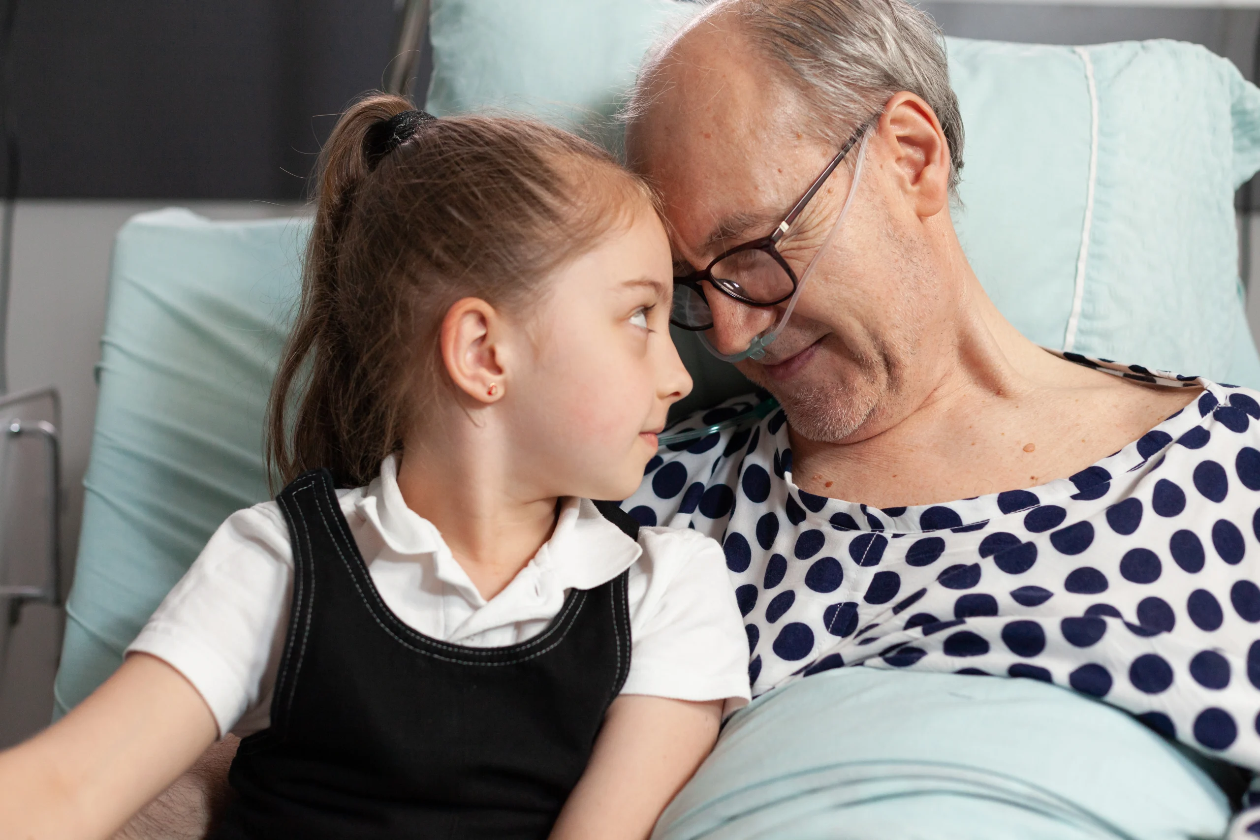 caring-cheerful-granddaughter-touching-forehead-with-sick-elderly-grandfather