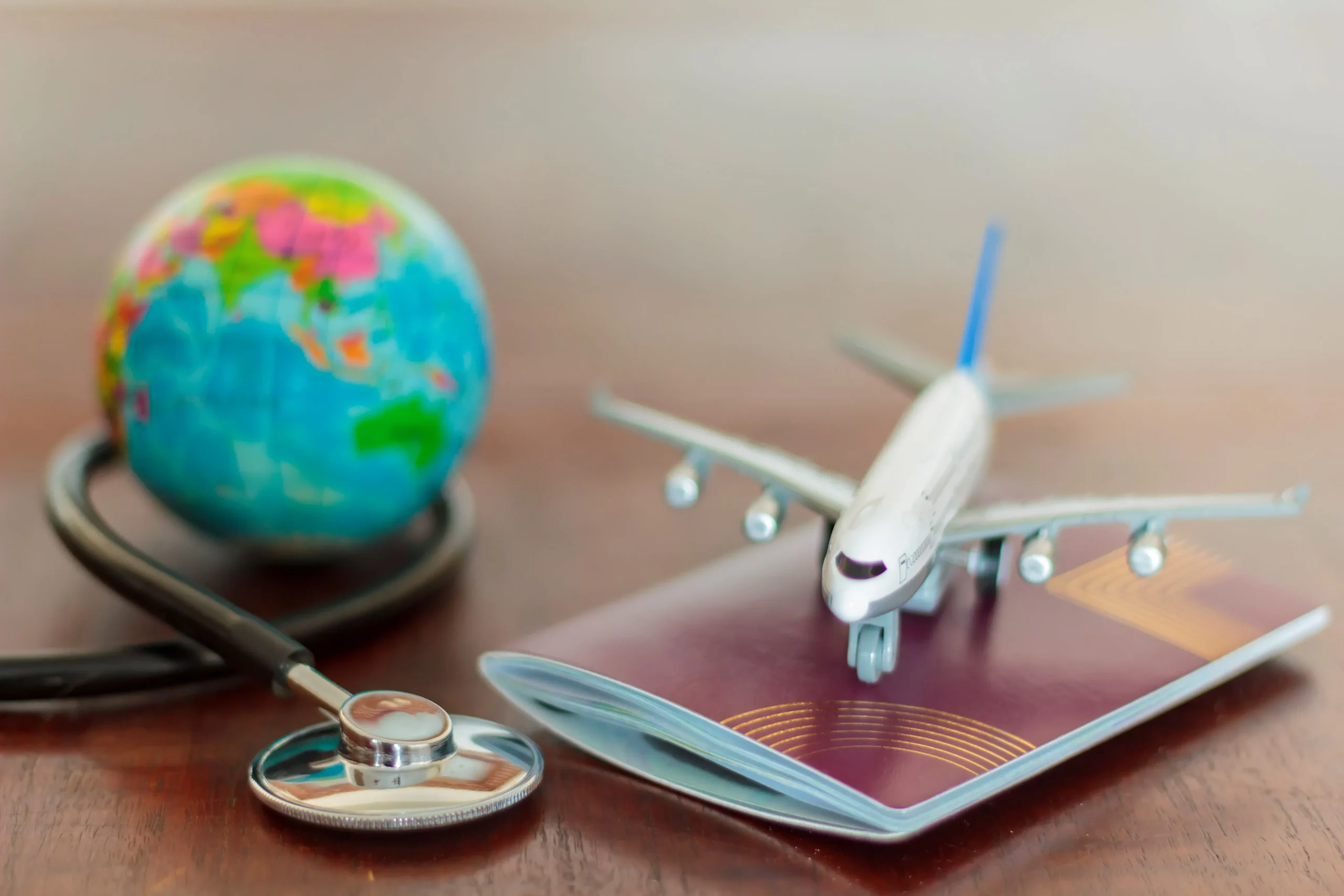 close-up-stethoscope-with-model-airplane-passport-table