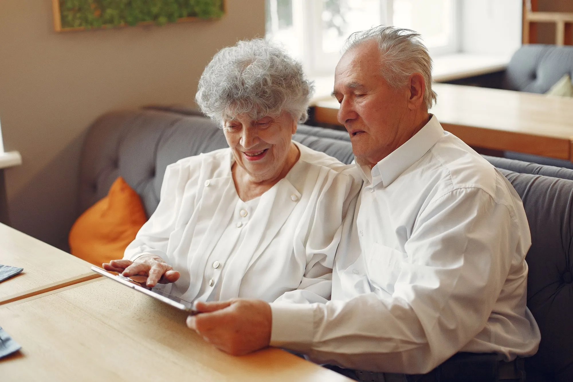 elegant-old-couple-cafe-using-tablet