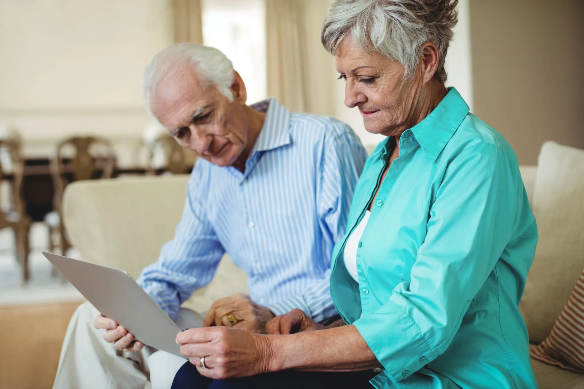 senior-couple-using-laptop-living-room