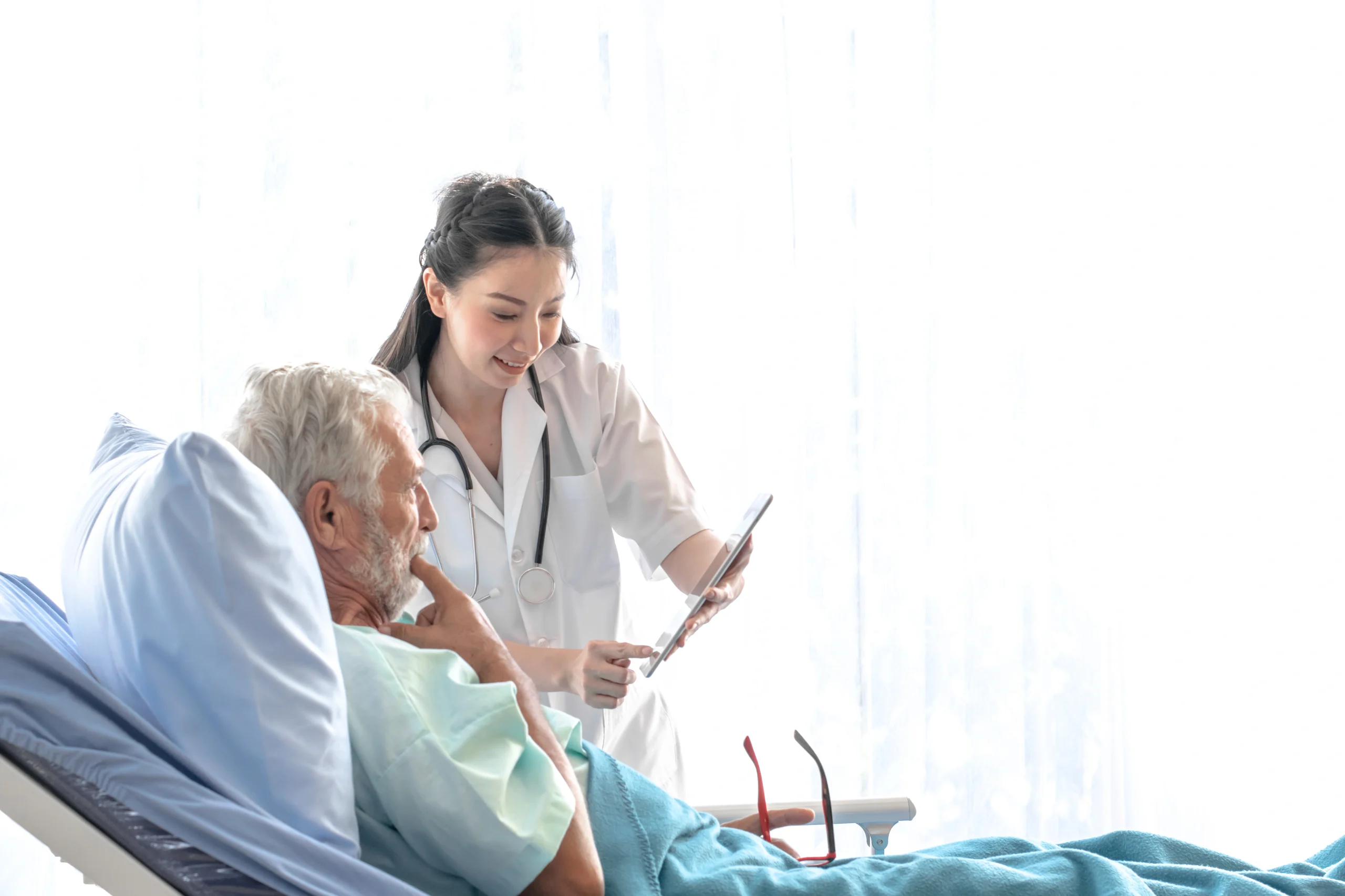 young-asian-woman-doctor-talking-with-old-man-patient-bed